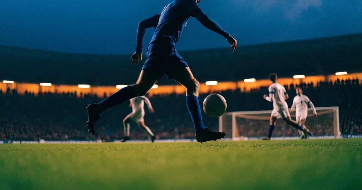 Ein großes Stadion bei Nacht, aus der Ferne unter Flutlicht gesehen, die Ränge hell erleuchtet, der Rasen leuchtend grün.