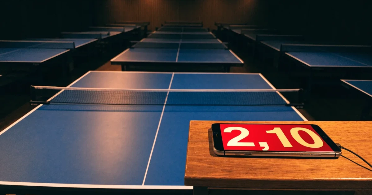Eine Tischtennishalle aus erhöhter Perspektive mit mehreren blauen Tischen in Reihen unter gedämpftem Hallenlicht, ohne Personen.